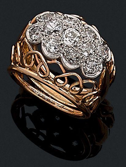 null 
RING

holding in its center a pavement of old cut diamonds. Platinum and 18K...