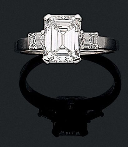 SOLITARY RING holding an emerald cut diamond...
