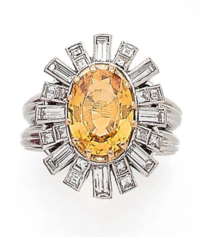 null 
RING 

decorated with a floral design holding an oval yellow sapphire in a...