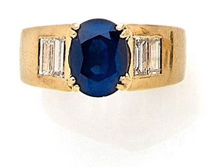 null RING holding an oval sapphire of approximately 1.80 carat with four tapered...