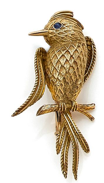 null BROCHE composée d'un oiseau sur une branche, en or texturé, retenant un saphir...
