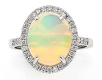 null RING holding an oval opal in a circle of brilliant-cut diamonds. Mounted in...