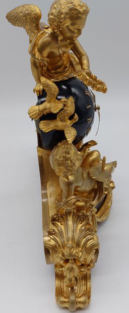 null A gilt bronze and chased globe clock decorated with putti and attributes. It...