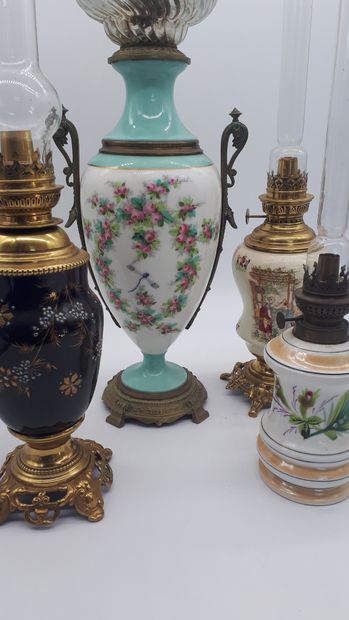 null ENSEMBLE DE 4 LAMPES A PETROLE en porcelaine, monture en laiton et bronze, décor...