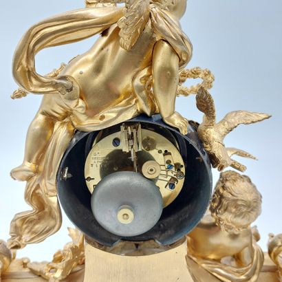 null A gilt bronze and chased globe clock decorated with putti and attributes. It...