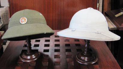 null Deux casques coloniaux vietnamiens présentés sur un porte chapeau en acajou....