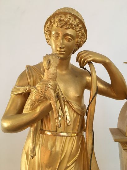 null PENDULE en bronze doré et ciselé à décor d'un jeune chasseur tenant un faon,...