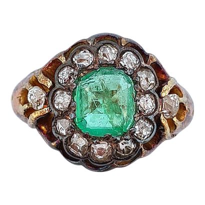 null RING 
decorated with a flower design holding a square emerald (accident) in...