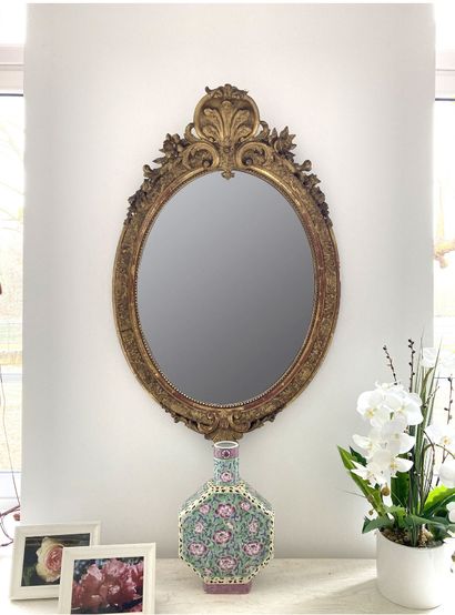 Oval mirror in wood and gilded stucco carved...