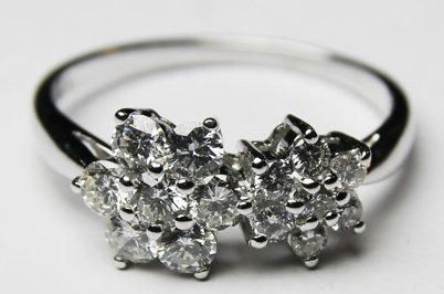 null BAGUE en or gris ornee de deux fleurs en diamants de taille brillant. ( env....