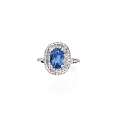 null RING 
holding a 2.41-carat oval sapphire in a double surround of round brilliant-cut...