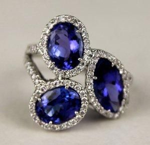 null BAGUE en or gris ornée de deux tanzanites ovales et une tanzanite taille navette...