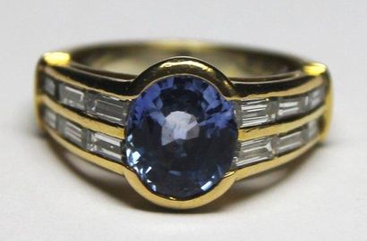 null BAGUE en or jaune ornée d'un saphir de taille ovale épaulé par deux lignes de...