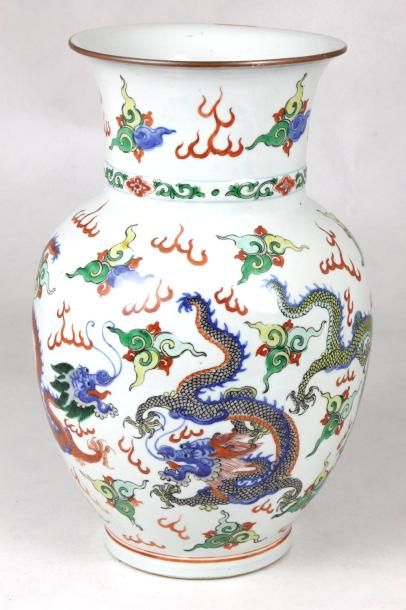 CHINE Vase de forme balustre en porcelaine polychrome sur fond blanc à décor de dragons....