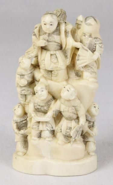 JAPON Groupe en ivoire sculpté représentant de nombreux enfants sur un rocher, signé....