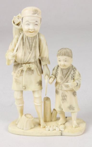 JAPON Groupe en ivoire sculpté figurant un homme et un enfant. Signé Gyokuzan XIXème...