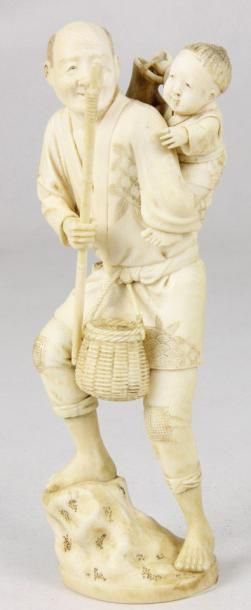 JAPON Statuette en ivoire sculpté représentant un homme au panier et un enfant dans...