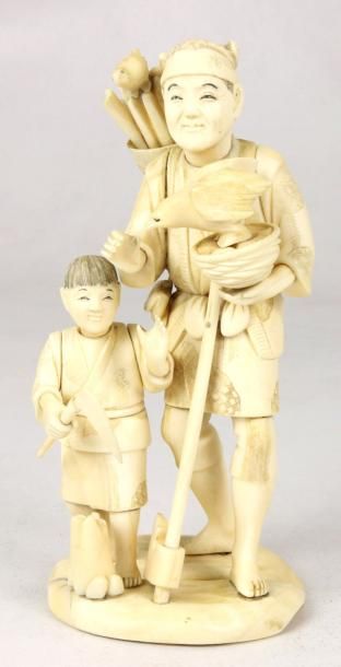 JAPON Groupe en ivoire sculpté représentant un homme avec un enfant et un homme portant...