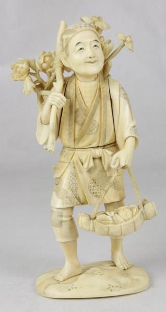 JAPON Okimono en ivoire sculpté figurant un homme aux paniers de fleurs. XIXème siècle...