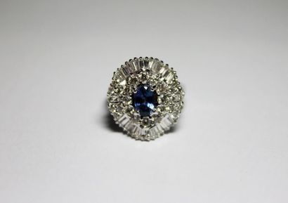 null BAGUE en or gris ornée d'un saphir dans un entourage de diamants de taille brillant...