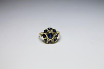 null BAGUE en or jaune ornée d'un saphir de taille ovale en sertie clos dans un entourage...