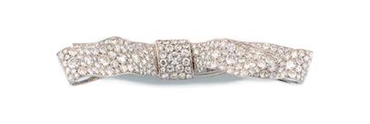 CARTIER BROCHE en platine et or gris stylisant un large noeud plat. Le noeud entierement...