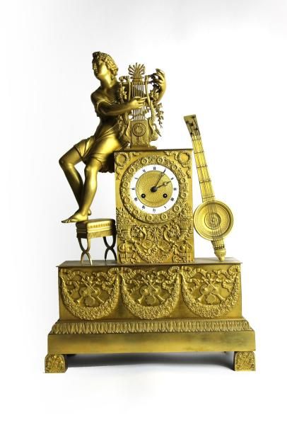 null PENDULE en bronze doré et ciselé à décor d'un Apollon à la Lyre, la base à couronnes...