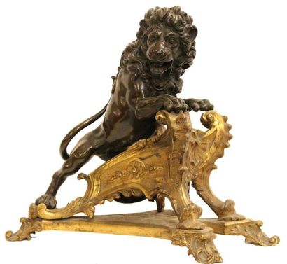 null CHENET en bronze doré et patiné à décor d'un lion rugissant. Piètement feuillagé...