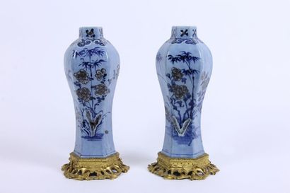 CHINE Paire de vases en porcelaine polychrome à fond bleu à décor de branchages fleuris....