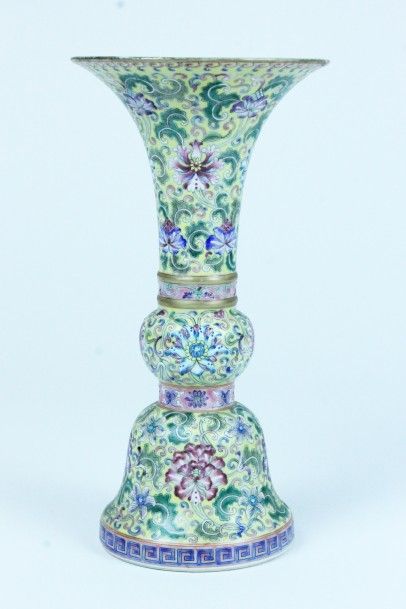 CHINE Vase cornet en porcelaine émaillée sur fond jaune à décor de fleurs de la Famille...