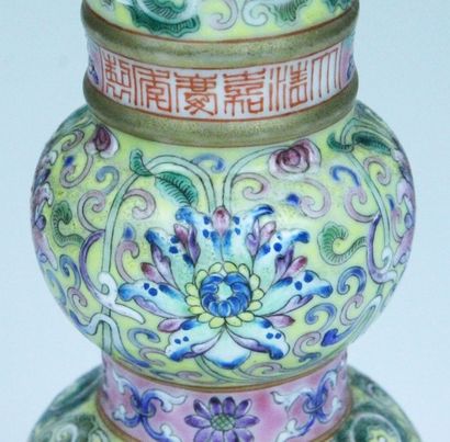 CHINE Vase cornet en porcelaine émaillée sur fond jaune à décor de fleurs de la Famille...