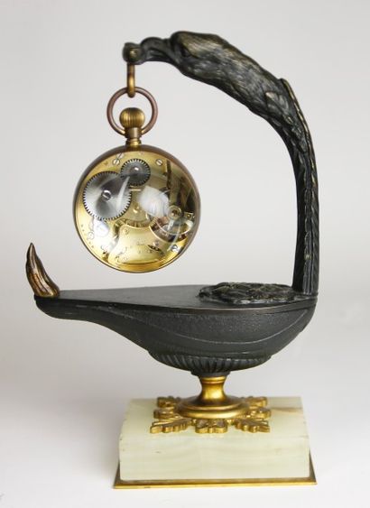 null PORTE-MONTRE en bronze patiné à décor d'urne à l'antique, la prise à tête d'aigle....