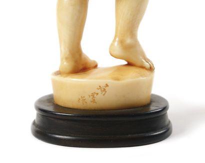 JAPON Okimono en ivoire finement sculpté représentant un enfant debout sur un tertre...