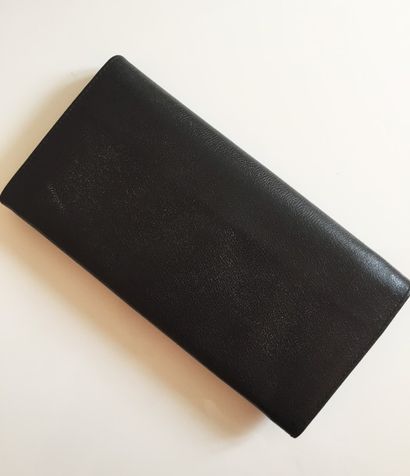 Yves Saint LAURENT PORTEFEUILLE en cuir noir. Etat presque neuf. 10 x 19,5 cm. Avec...