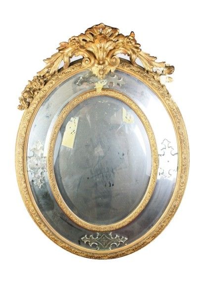 null MIROIR A PARECLOSES de forme ovale en bois doré, mouluré et sculpté orné d'une...