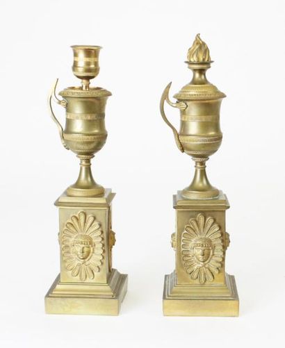 null PAIRE DE BOUGEOIRS en bronze doré à décor d'une urne enflammée reposant sur...