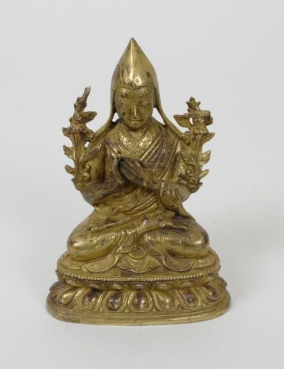 null TIBET vers 1900 Figure d'un moine tibétain en bronze doré assis sur un socle...