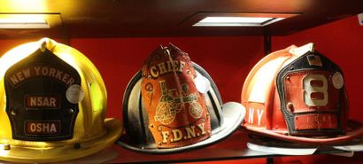 null " Casques, New-York, U.S.A" Trois casques en cuir bouilli de pompier de la ville...
