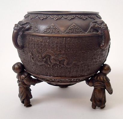 null CHINE Cache-pot en bronze patiné et repoussé reposant sur un piètement tripode...