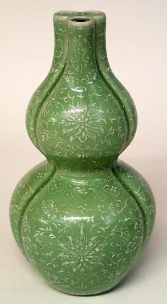 null CHINE Vase gourde en porcelaine céladon à décor en relief de fleurs. Cachet...