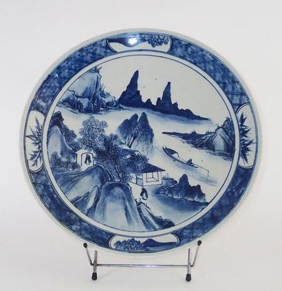 null CHINE Grand plat en porcelaine décoré en bleu sous couverte d'un paysage fluvial...