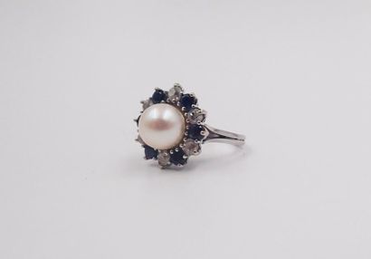 null BAGUE en or gris ornée d'une perle, dans un entourage de saphirs de taille ronde...