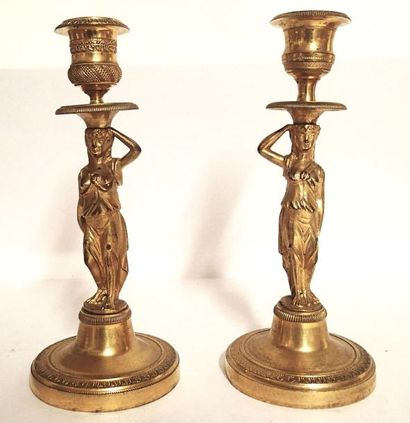 null PAIRE DE BOUGEOIRS en bronze doré et ciselé à décor de cariatides. XIXème siècle...
