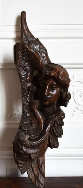 null ELEMENT DECORATIF en bois sculpté en fort relief à décor d’une tête d’ange entourée...