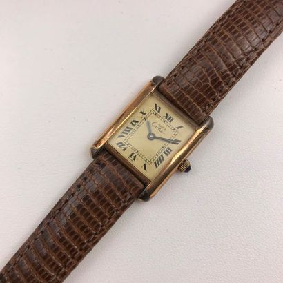 null A plated gold wriswatch by Cartier "Must".
Bracelet en cuir marron et boucle...