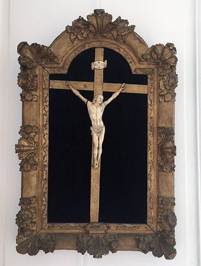 null CHRIST en ivoire sculpté sur sa Croix dans un encadrement en bois doré à fronton...