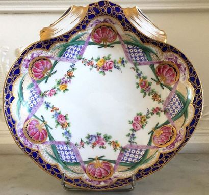 null COUPELLE en porcelaine en forme de coquille à décor émaillé de fleurs. Fin XIXème...
