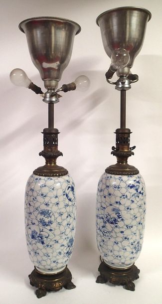  JAPON Paire de vases ovoides montés en lampe en faience bleu blanc à décor floral....