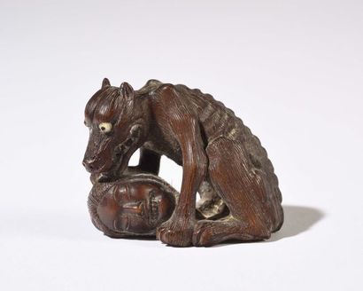 null JAPON : Netsuké en bois sculpté représentant un loup léchant la tête d’un révolutionnaire...