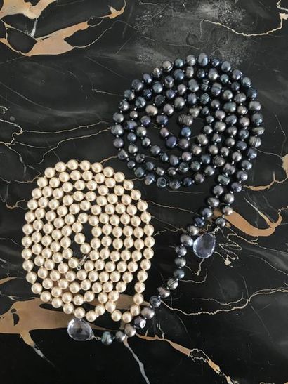 null LOT comprenant: Deux sautoir en perle:un constitué de perles blanches et l'autres...